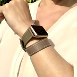 Hazel Brown Double Wrap Apple Watch Leather Band by Juxli Home.  Handmade, stylish leather strap with rose gold hardware on a 40mm Apple watch on a canvas with a black and gray painting.