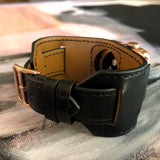 Black Apple Watch Leather Cuff by Juxli Home.  Handmade, stylish leather strap with rose gold hardware on a 40mm Apple watch on a canvas with a black and gray painting.