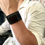 Black Apple Watch Leather Cuff by Juxli Home.  Handmade, stylish leather strap with rose gold hardware on a 40mm Apple watch on a canvas with a black and gray painting.