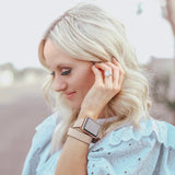 Blush Rose Double Wrap Apple Watch Leather Band for Women by Juxli Home.  Handmade, stylish leather strap with rose gold hardware on a 40mm Apple watch on a canvas with a black and gray painting.