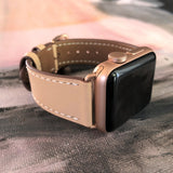 Blush Rose Apple Watch Leather Band by Juxli Home.  Handmade, stylish leather strap with rose gold hardware on a 40mm Apple watch on a canvas with a black and gray painting.