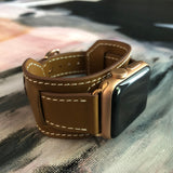 Caramel Brown Apple Watch Leather Cuff by Juxli Home.  Handmade, stylish leather strap with rose gold hardware on a 40mm Apple watch on a canvas with a black and gray painting.