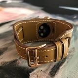 Caramel Brown Apple Watch Leather Cuff by Juxli Home.  Handmade, stylish leather strap with rose gold hardware on a 40mm Apple watch on a canvas with a black and gray painting.