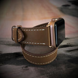 Caramel Brown Double Wrap Apple Watch Leather Band by Juxli Home.  Handmade, stylish leather strap with rose gold hardware on a 40mm Apple watch on a canvas with a black and gray painting.