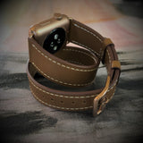 Caramel Brown Double Wrap Apple Watch Leather Band by Juxli Home.  Handmade, stylish leather strap with rose gold hardware on a 40mm Apple watch on a canvas with a black and gray painting.