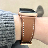 Cognac Brown Apple Watch Leather Band by Juxli Home.  Handmade, stylish leather strap with rose gold hardware on a 40mm Apple watch on a canvas with a black and gray painting.