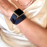 Space Blue Double Wrap Apple Watch Leather Band by Juxli Home.  Handmade, stylish leather strap with rose gold hardware on a 40mm Apple watch on a canvas with a black and gray painting.