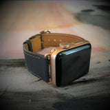 Charcoal Gray Apple Watch Leather Band by Juxli Home.  Handmade, stylish leather strap with rose gold hardware on a 40mm Apple watch on a canvas with a black and gray painting.