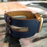 Space Blue Apple Watch Double Buckle Leather Cuff by Juxli Home.  Handmade, stylish leather strap with rose gold hardware on a 40mm Apple watch on a canvas with a black and gray painting.