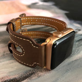 Chocolate Brown Double Buckle Apple Watch Leather Cuff by Juxli Home.  Handmade, stylish leather strap with rose gold hardware on a 40mm Apple watch on a canvas with a black and gray painting.