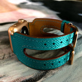 Sea Green Apple Watch Double Buckle Leather Cuff by Juxli Home.  Handmade, stylish leather strap with rose gold hardware on a 40mm Apple watch on a canvas with a black and gray painting.