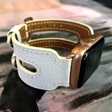 White Apple Watch Double Buckle Leather Cuff by Juxli Home.  Handmade, stylish leather strap with rose gold hardware on a 40mm Apple watch on a canvas with a black and gray painting.