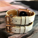 White Apple Watch Double Buckle Leather Cuff by Juxli Home.  Handmade, stylish leather strap with rose gold hardware on a 40mm Apple watch on a canvas with a black and gray painting.