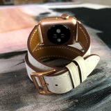 Women’s Ivory Double Wrap Apple Watch Leather Band by Juxli Home.  Handmade, stylish leather strap with rose gold hardware on a 40mm Apple watch on a canvas with a black and gray painting.