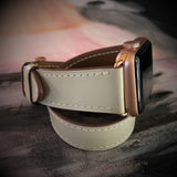 Ladies Sage Gray Double Wrap Apple Watch Leather Band by Juxli Home.  Handmade, stylish leather strap with rose gold hardware on a 40mm Apple watch on a canvas with a black and gray painting.