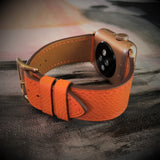 Summer Orange Textured Leather Apple Watch Band by Juxli Home.  Handmade, stylish leather strap with rose gold hardware on a 40mm Apple watch on a canvas with a black and gray painting.