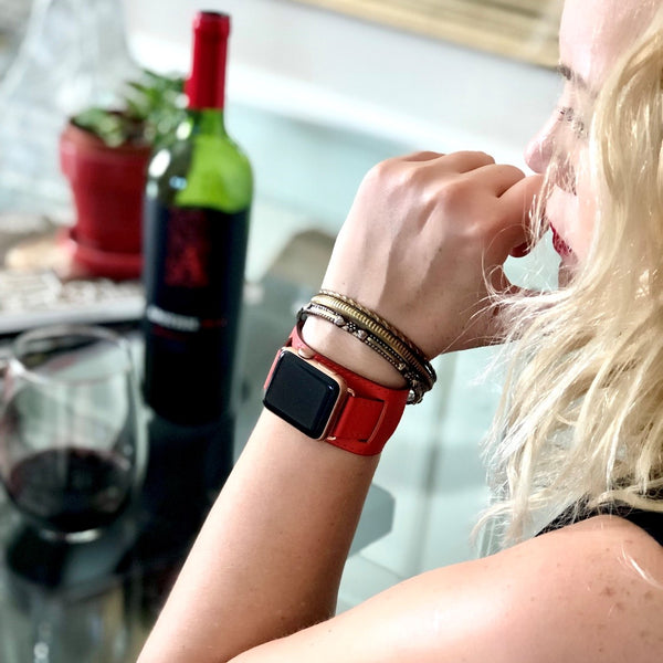 Fire Red Apple Watch Leather Cuff by Juxli Home. Handmade, stylish leather strap with rose gold hardware on a 40mm Apple watch on a canvas with a black and gray painting.