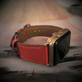 Fire Red Apple Watch Leather Band by Juxli Home.  Handmade, stylish leather strap with rose gold hardware on a 40mm Apple watch on a canvas with a black and gray painting.