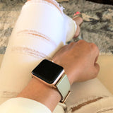 Sage Gray Apple Watch Band by Juxli Home.  Handmade, stylish leather strap with rose gold hardware on a 40mm Apple watch on a canvas with a black and gray painting.