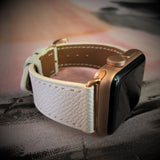 Textured White Apple Watch Band by Juxli Home.  Handmade, stylish leather strap with rose gold hardware on a 40mm Apple watch on a canvas with a black and gray painting.