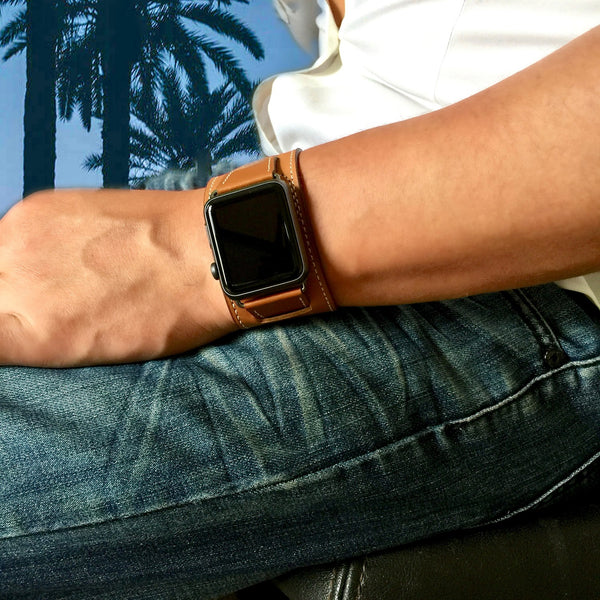 Caramel Brown Apple Watch Leather Cuff by Juxli Home. Handmade, stylish leather strap with rose gold hardware on a 40mm Apple watch on a canvas with a black and gray painting.