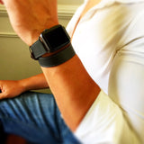 Charcoal Gray Double Wrap Apple Watch Band by Juxli Home.  Handmade, stylish leather strap with rose gold hardware on a 40mm Apple watch on a canvas with a black and gray painting.