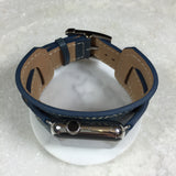 Navy Blue Apple Watch Leather Cuff by Juxli Home.  Handmade, stylish leather strap with rose gold hardware on a 40mm Apple watch on a canvas with a black and gray painting.
