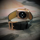 Black Apple Watch Leather Band by Juxli Home.  Handmade, stylish leather strap with rose gold hardware on a 40mm Apple watch on a canvas with a black and gray painting.