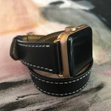 Jet Black Double Wrap Apple Watch Leather Band with White Stitching by Juxli Home.  Handmade, stylish leather strap with rose gold hardware on a 40mm Apple watch on a canvas with a black and gray painting.