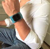Cyan Blue Apple Watch Leather Cuff by Juxli Home.  Handmade, stylish leather strap with rose gold hardware on a 40mm Apple watch on a canvas with a black and gray painting.