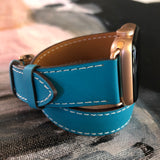 Cyan Blue Double Wrap Apple Watch Leather Band by Juxli Home.  Handmade, stylish leather strap with rose gold hardware on a 40mm Apple watch on a canvas with a black and gray painting.