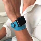 Cyan Blue Double Wrap Apple Watch Leather Band by Juxli Home.  Handmade, stylish leather strap with rose gold hardware on a 40mm Apple watch on a canvas with a black and gray painting.