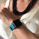 Cyan Blue Apple Watch Band by Juxli Home.  Handmade, stylish leather strap with rose gold hardware on a 40mm Apple watch on a canvas with a black and gray painting.