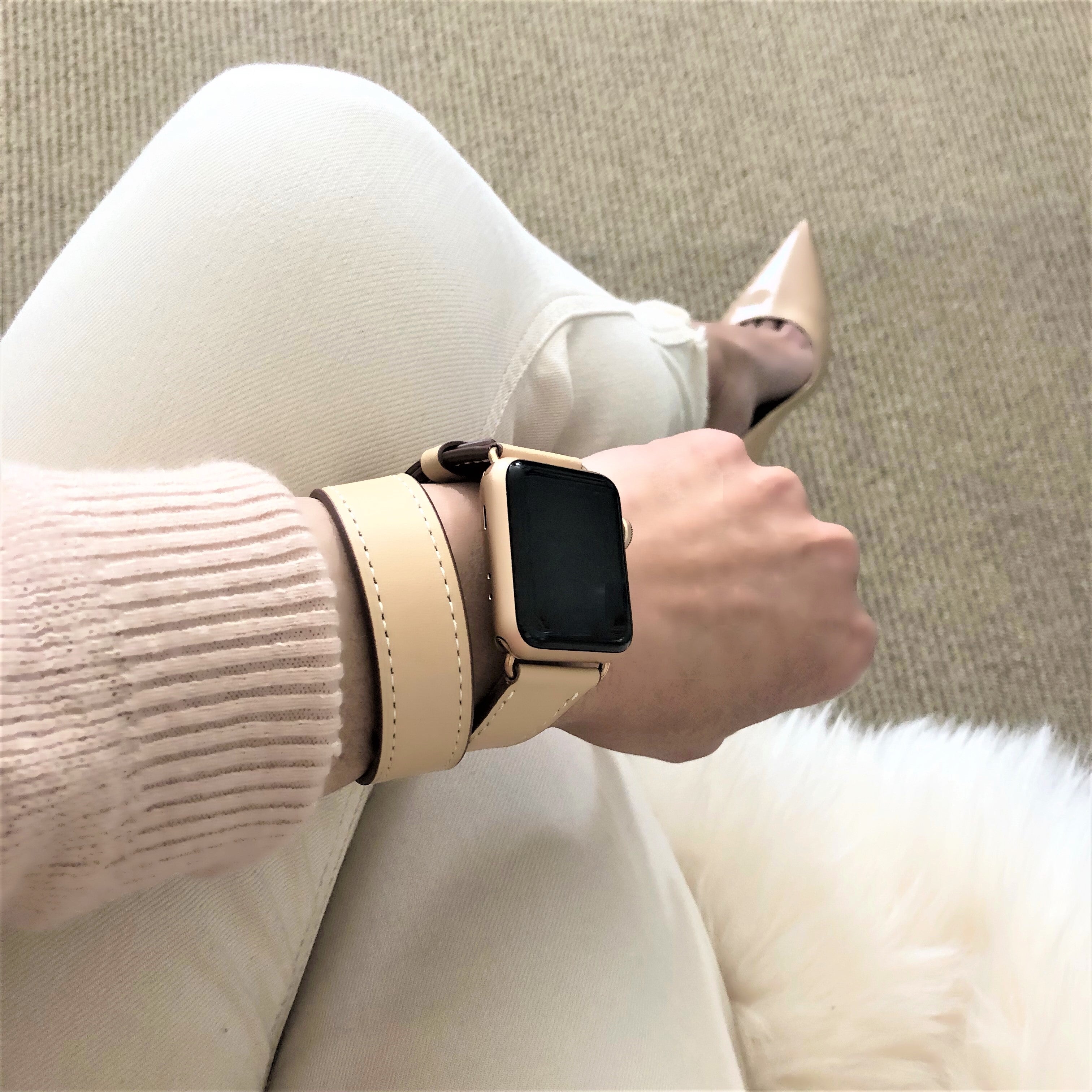 Blush Rose Double Wrap Apple Watch Leather Band for Women by Juxli Home.  Handmade, stylish leather strap with rose gold hardware on a 40mm Apple watch on a canvas with a black and gray painting.