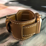 Caramel Brown Apple Watch Leather Cuff by Juxli Home.  Handmade, stylish leather strap with rose gold hardware on a 40mm Apple watch on a canvas with a black and gray painting.