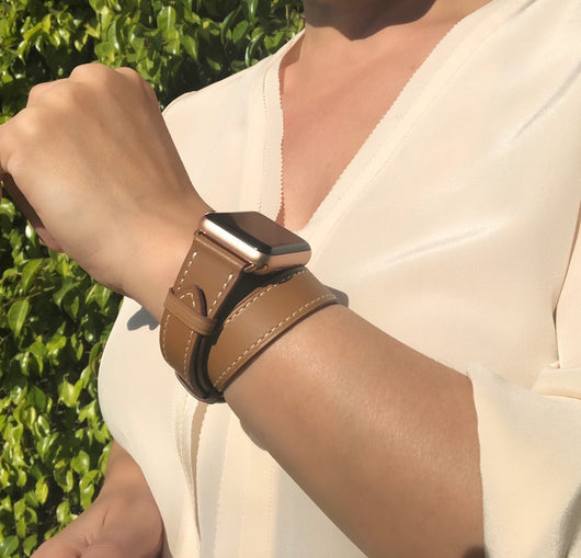 Caramel Brown Double Wrap Apple Watch Leather Band by Juxli Home.  Handmade, stylish leather strap with rose gold hardware on a 40mm Apple watch on a canvas with a black and gray painting.