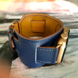 Space Blue Apple Watch Leather Cuff by Juxli Home.  Handmade, stylish leather strap with rose gold hardware on a 40mm Apple watch on a canvas with a black and gray painting.