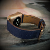 Space Blue Textured Leather Apple Watch Band by Juxli Home.  Handmade, stylish leather strap with rose gold hardware on a 40mm Apple watch on a canvas with a black and gray painting.