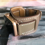 Hazel Brown Apple Watch Leather Cuff by Juxli Home.  Handmade, stylish leather strap with rose gold hardware on a 40mm Apple watch on a canvas with a black and gray painting.