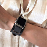 Dark Gray Apple Watch Leather Cuff by Juxli Home.  Handmade, stylish leather strap with rose gold hardware on a 40mm Apple watch on a canvas with a black and gray painting.