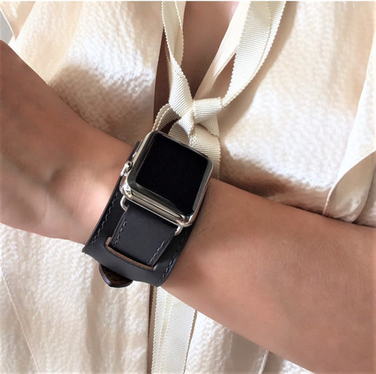 Dark Gray Apple Watch Leather Cuff by Juxli Home.  Handmade, stylish leather strap with rose gold hardware on a 40mm Apple watch on a canvas with a black and gray painting.