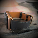 Charcoal Gray Apple Watch Leather Band by Juxli Home.  Handmade, stylish leather strap with rose gold hardware on a 40mm Apple watch on a canvas with a black and gray painting.