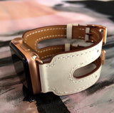 Ivory Apple Watch Double Buckle Cuff by Juxli Home.  Handmade, stylish leather strap with rose gold hardware on a 40mm Apple watch on a canvas with a black and gray painting.