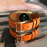 Summer Orange Double Buckle Apple Watch Leather Cuff by Juxli Home.  Handmade, stylish leather strap with rose gold hardware on a 40mm Apple watch on a canvas with a black and gray painting.