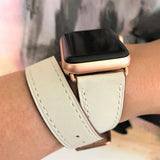 Women’s Ivory Double Wrap Apple Watch Leather Band by Juxli Home.  Handmade, stylish leather strap with rose gold hardware on a 40mm Apple watch on a canvas with a black and gray painting.