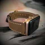 Caramel Brown Apple Watch Leather Band by Juxli Home.  Handmade, stylish leather strap with rose gold hardware on a 40mm Apple watch on a canvas with a black and gray painting.