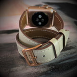 Ladies Sage Gray Double Wrap Apple Watch Leather Band by Juxli Home.  Handmade, stylish leather strap with rose gold hardware on a 40mm Apple watch on a canvas with a black and gray painting.