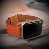 Summer Orange Textured Leather Apple Watch Band by Juxli Home.  Handmade, stylish leather strap with rose gold hardware on a 40mm Apple watch on a canvas with a black and gray painting.