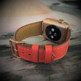 Fire Red Apple Watch Leather Band by Juxli Home.  Handmade, stylish leather strap with rose gold hardware on a 40mm Apple watch on a canvas with a black and gray painting.