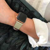 Sage Gray Apple Watch Band by Juxli Home.  Handmade, stylish leather strap with rose gold hardware on a 40mm Apple watch on a canvas with a black and gray painting.